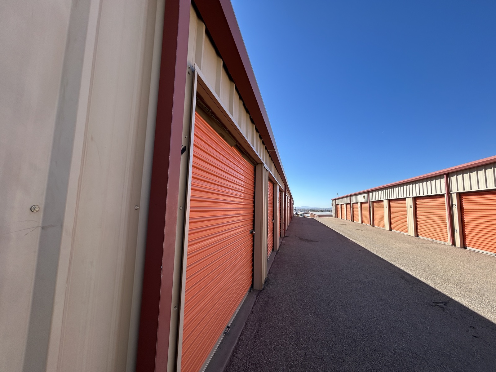 Rows of secure storage units with orange roll-up doors